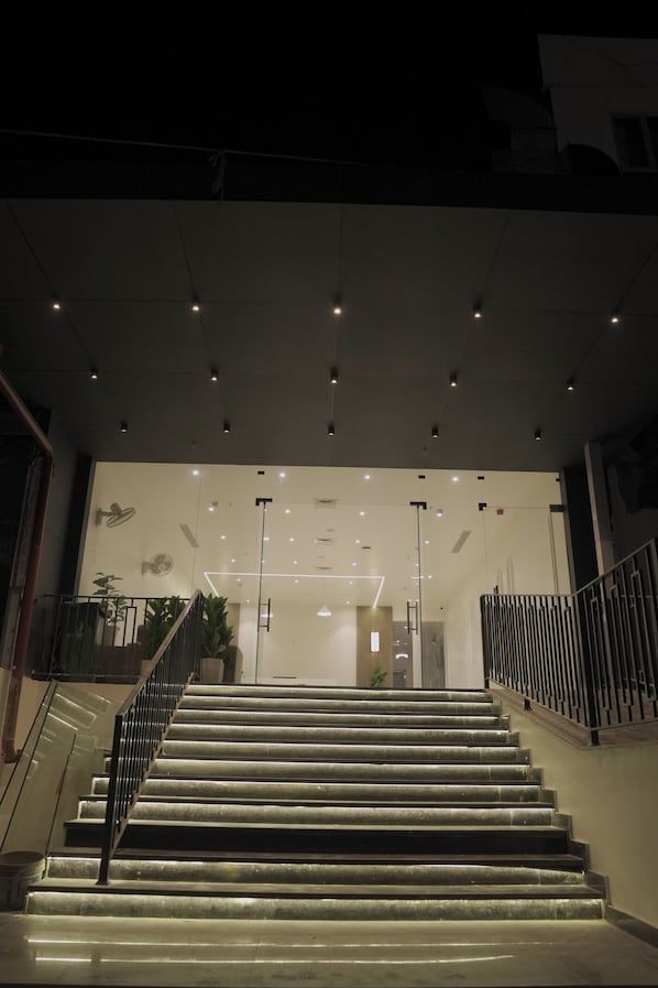 A staircase leading to a building entrance with a modern design, including a glass door and a metal railing. - Hotel Vifa Retreat (Lucknow)