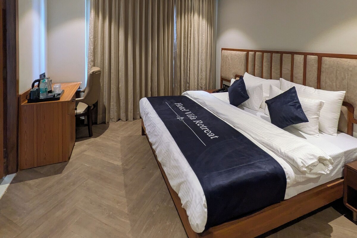 A hotel room with a bed, a desk, and a chair.