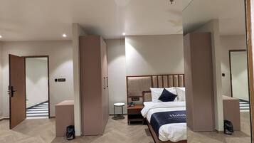 Una habitación de hotel moderna con una cama grande, una mesita de noche y un espejo.