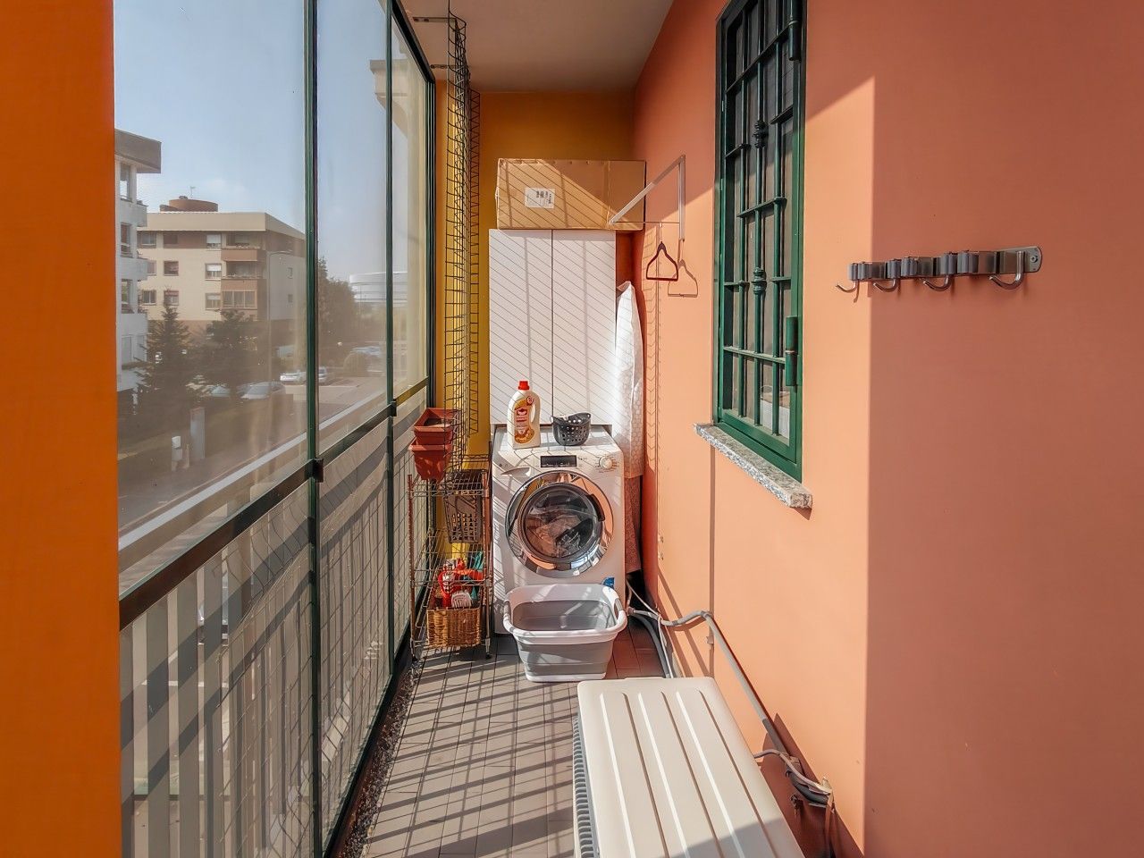 Un balcone piccolo e funzionale, con lavatrice, stendibiancheria e una piccola finestra.