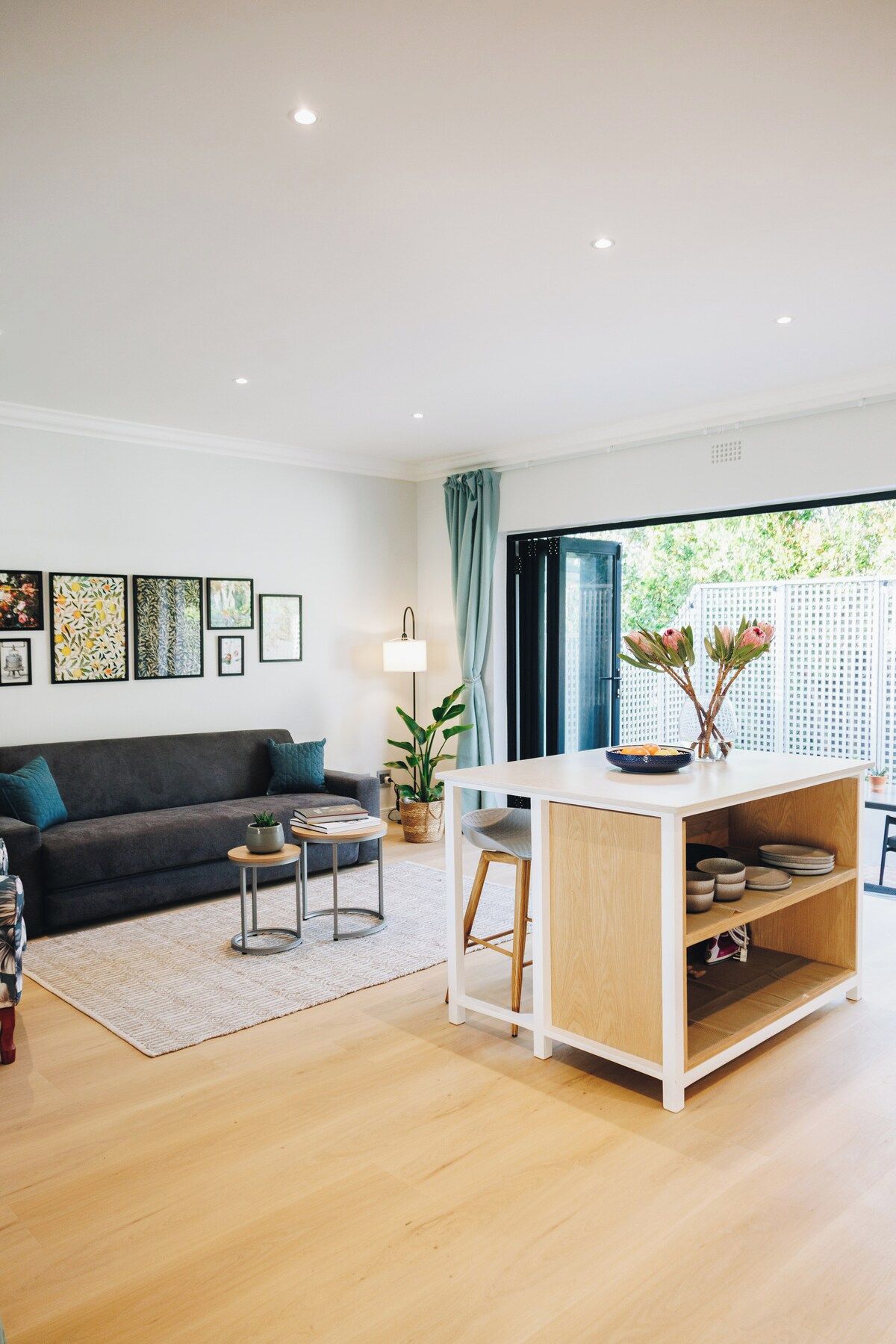 Un salon moderne comprenant un canapé, une table basse et un coin repas avec une table et des chaises.