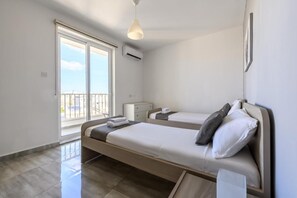 Et hotelværelse med to senge, en balkon og et moderne design.