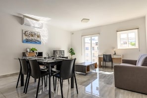 En moderne stue med spiseplads, sofa og skrivebord.