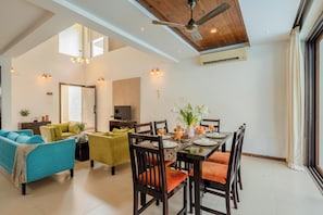 A spacious living area with a dining table set for six, surrounded by comfortable seating. - Staymaster Aqua Sol - 3BR Villas w Pool (Assagao)