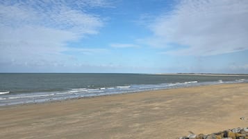 A beach with a rocky shoreline and a clear sky.