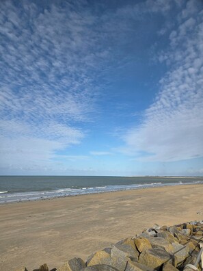 A beach with a rocky shoreline and a clear sky.