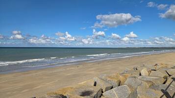 A beach with a clear sky and waves.