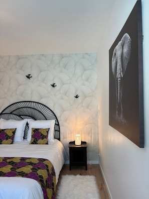 A bedroom with a bed, a nightstand, a wall-mounted lamp, and a framed artwork. - New Listing (La Redorte)