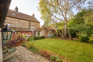 A traditional brick house with a well-maintained garden, stone pathway, and a large tree. - Host & Stay | Newtondale (Hutton-le-Hole)