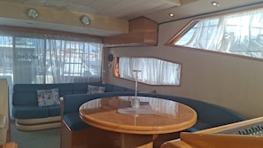 A room with a blue sofa, a round wooden table, and a window with curtains.