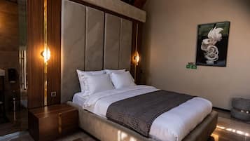 Un dormitorio moderno con una cama grande, cabecera de madera y un cuadro en la pared.