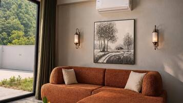 A modern living room with a sofa, two wall-mounted lamps, a painting, and a round table with a vase.