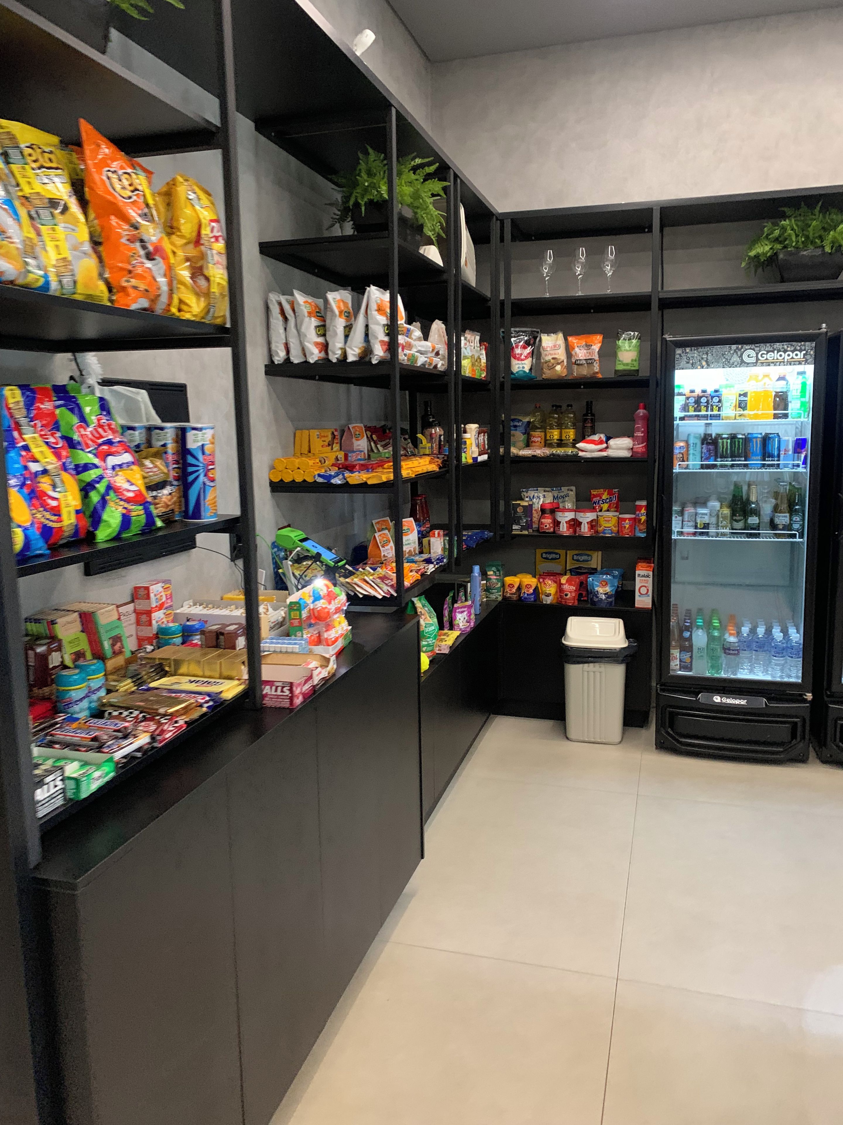 Un quiosco autoservicio con estantes llenos de diversos refrigerios, bebidas y aderezos.