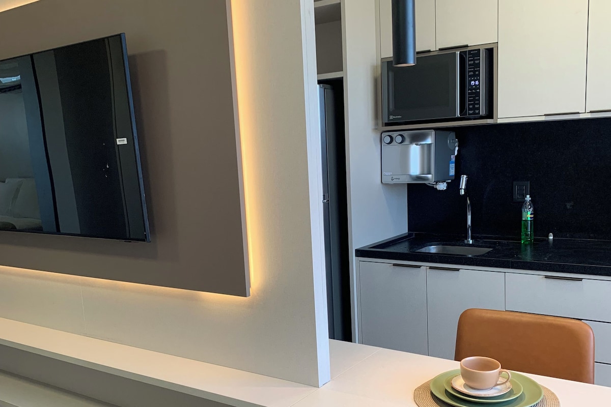 Une cuisine moderne équipée d’un four à micro-ondes encastré, d’un évier et d’un plan de travail.