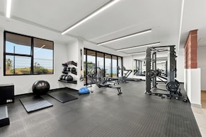 A gym with various exercise equipment, large windows, and a rubber mat floor. - Panoramic Ocean-View 3BR York Penthouse (Umhlanga)