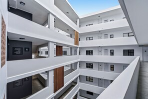 En bygning i flere etager med moderne arkitektur, inklusive reception, klublokale, fitnesscenter, vaskeri og fælles arbejdsområde.