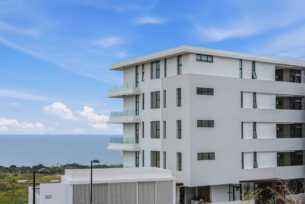 A multi-story building with balconies, a flat roof, and a view of the sea. - Panoramic Ocean-View 3BR York Penthouse (Umhlanga)