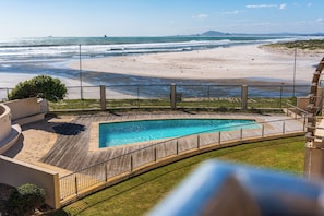Piscina com vista para a praia e oceano.