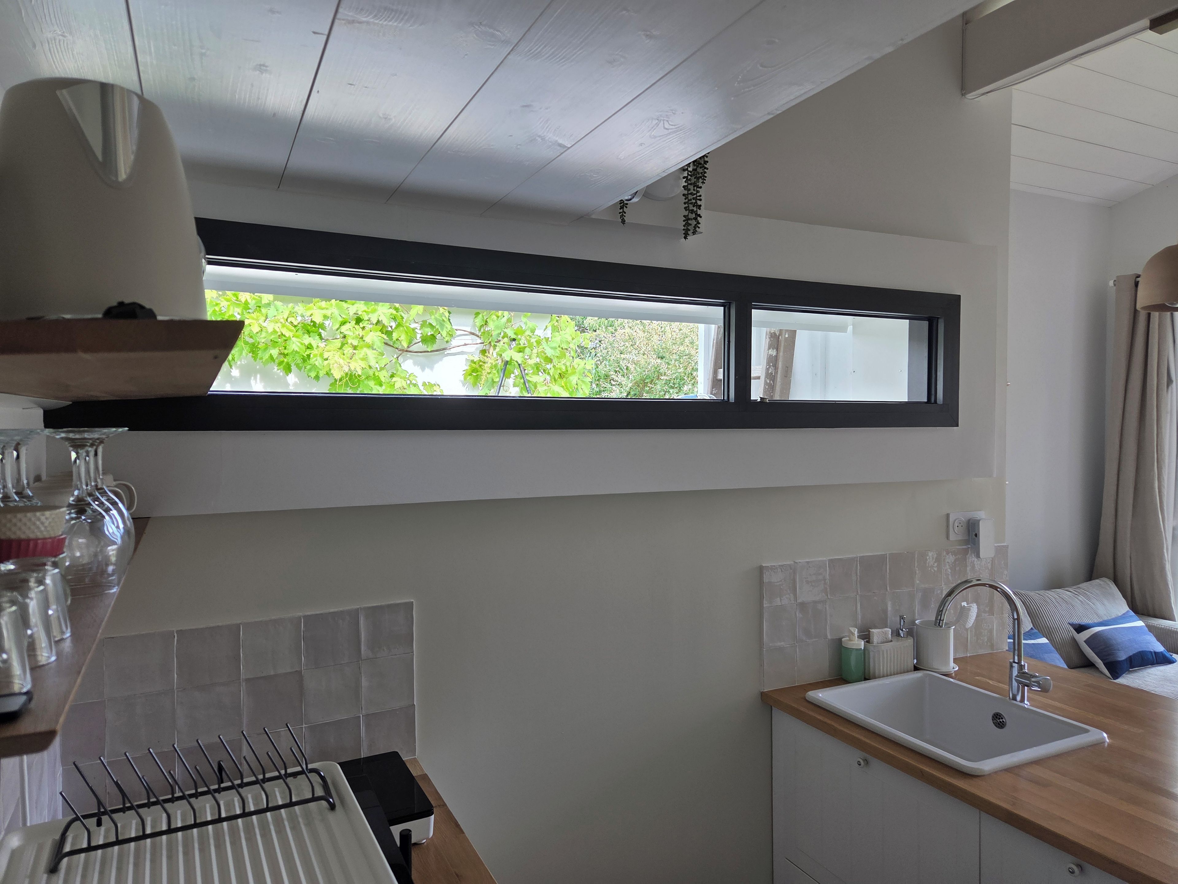 Een keuken met een raam, een spoelbak en een aanrecht.