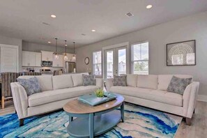 A modern living room with a sectional sofa, a coffee table, and a blue rug.