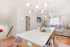 A modern kitchen with a central island, pendant lighting, and a view to a living area with a sofa. - NEW HOUSE Nash Bash Babes 2 BED/2BATH - Sleeps 10 (Nashville)