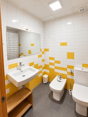 A modern bathroom with two sinks, a bidet, and a toilet.