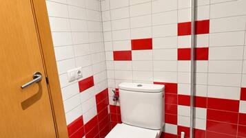 Un baño con inodoro, ducha y lavamanos.