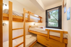A bunk bed room with a window, a bedside table, and a wall-mounted lamp. - Perce Neige - Proche piste olympique Luc (Saint-Chaffrey)
