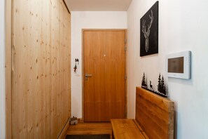 Eine Holztür mit Griff, ein kleines Wandthermostat und ein dekoratives Wandbild.