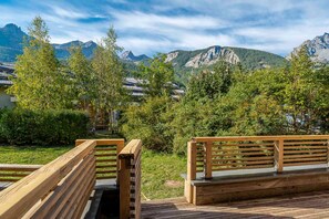Eine Holzterrasse mit Bänken mit Blick auf eine Berglandschaft.
