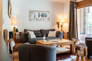 Ein gemütliches Wohnzimmer mit einer Couch, einem Couchtisch und einem Bild an der Wand.