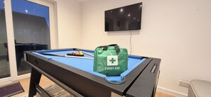 A pool table with a green bag labeled 'FIRST AID' and a television mounted on the wall. - NEW I 3 BEDROOM HOUSE I DUDLEY I WEST MIDLANDS I POOL TABLE I FAMILY (Dudley)