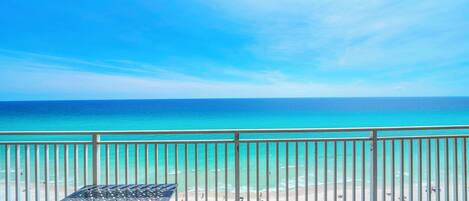 A balcony with a view of the ocean and beach.