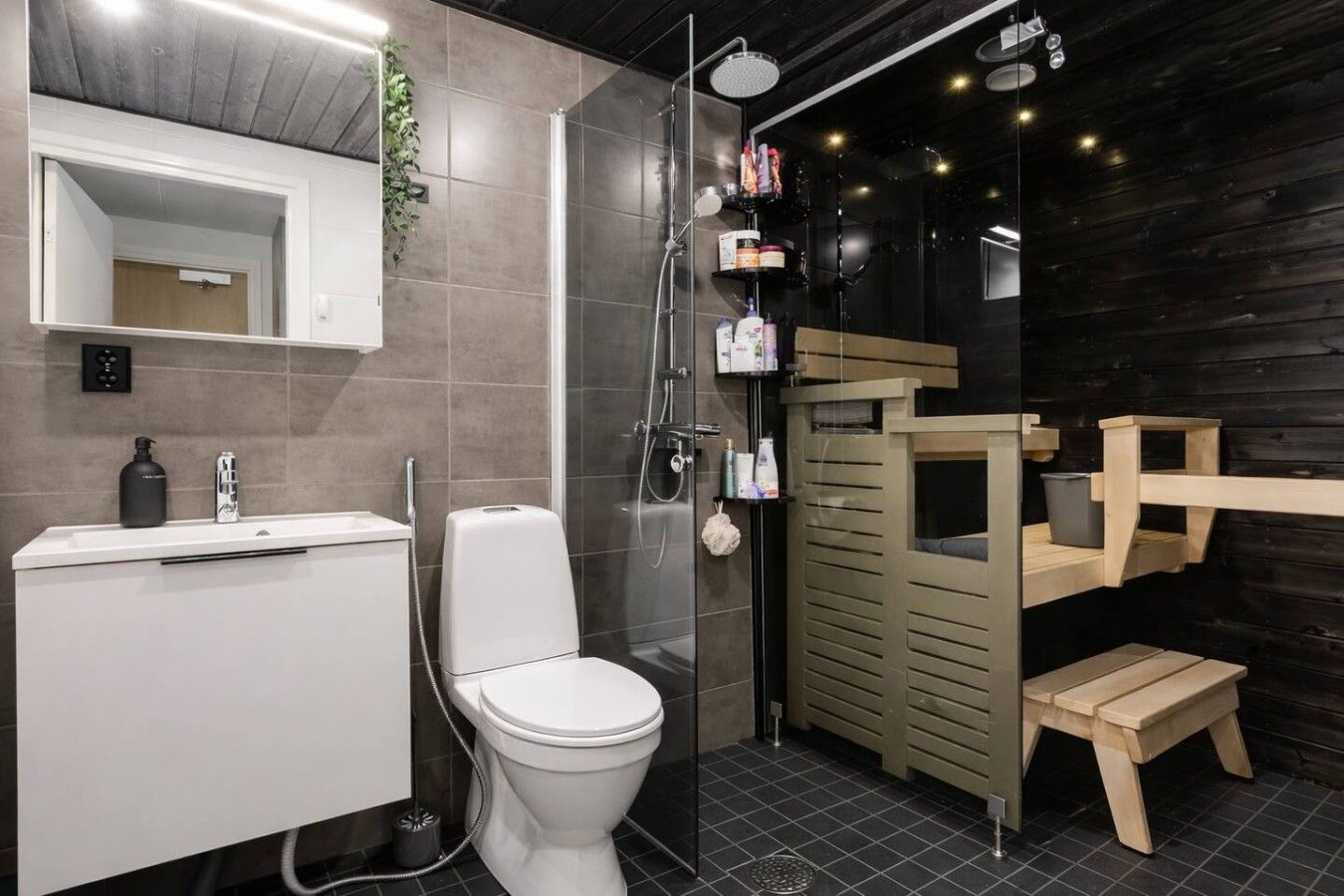 Ein modernes Badezimmer mit Toilette, Waschbecken und Dusche.