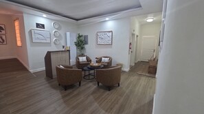 Ein modernes Wohnzimmer mit Essbereich, ausgestattet mit einer Sofagarnitur, einem Couchtisch und einer Zimmerpflanze.