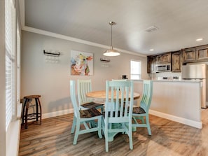 A kitchen with a dining area, wooden flooring, and a hanging light fixture. - Cozy 2 Bedroom Apartment in Historic Granbury (Granbury)