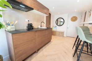 A modern kitchen with wooden cabinets, a black countertop, and a built-in oven. - New Listing (Nice)