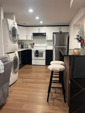 Eine moderne Küche mit Einbauwaschmaschine, Herd und Kühlschrank.