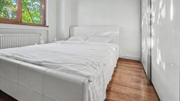 Una camera da letto moderna con un letto grande, un termosifone e una finestra.