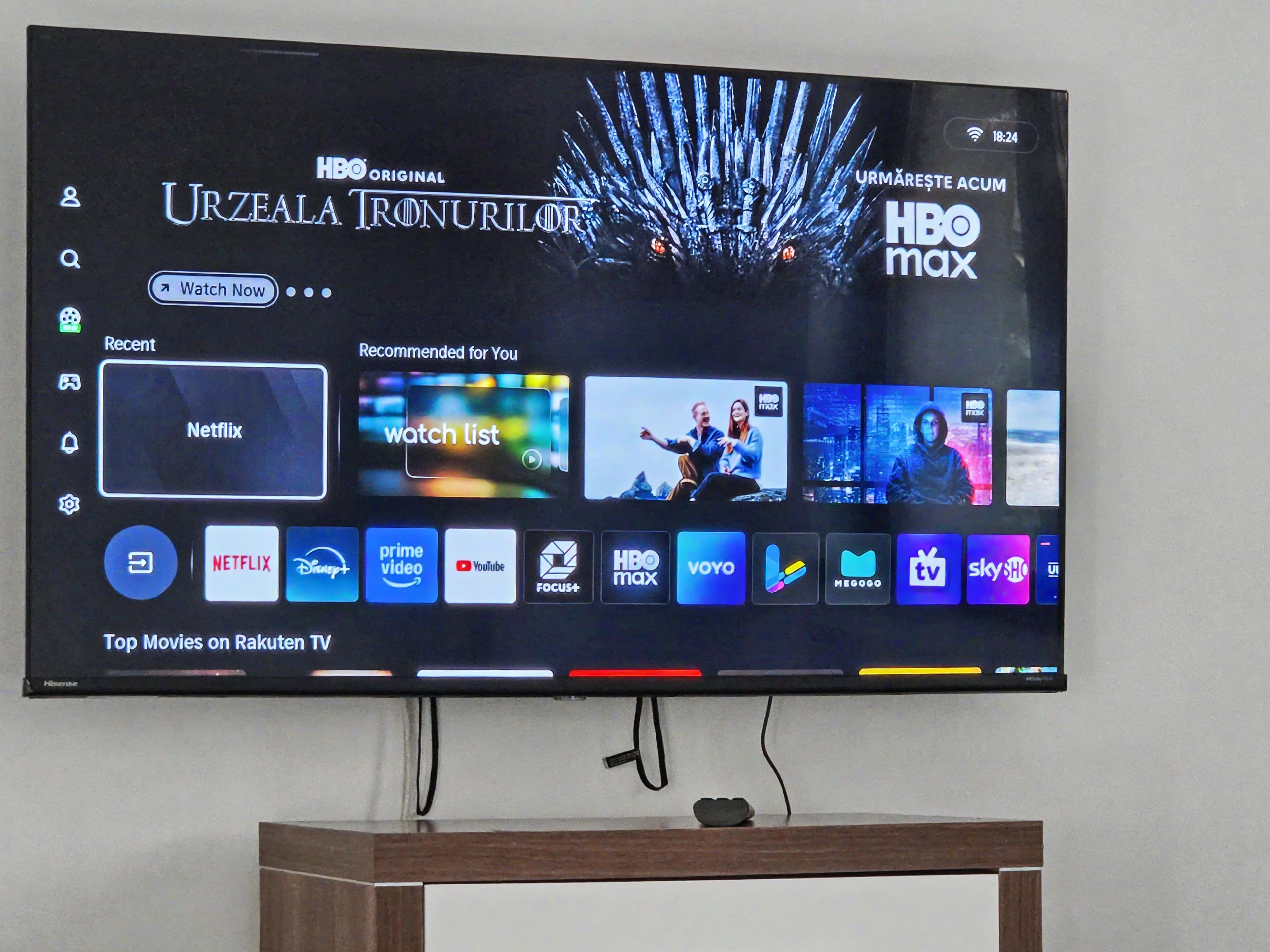 A flat-screen TV mounted on a wall displaying a streaming service interface with multiple app icons.