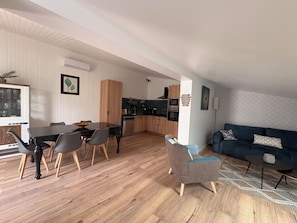 Een moderne woonruimte met een eethoek, keuken en zithoek.