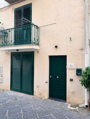 A building with a green door, a balcony with green railings, and a small sign above the door. - New Listing (Vietri sul Mare)