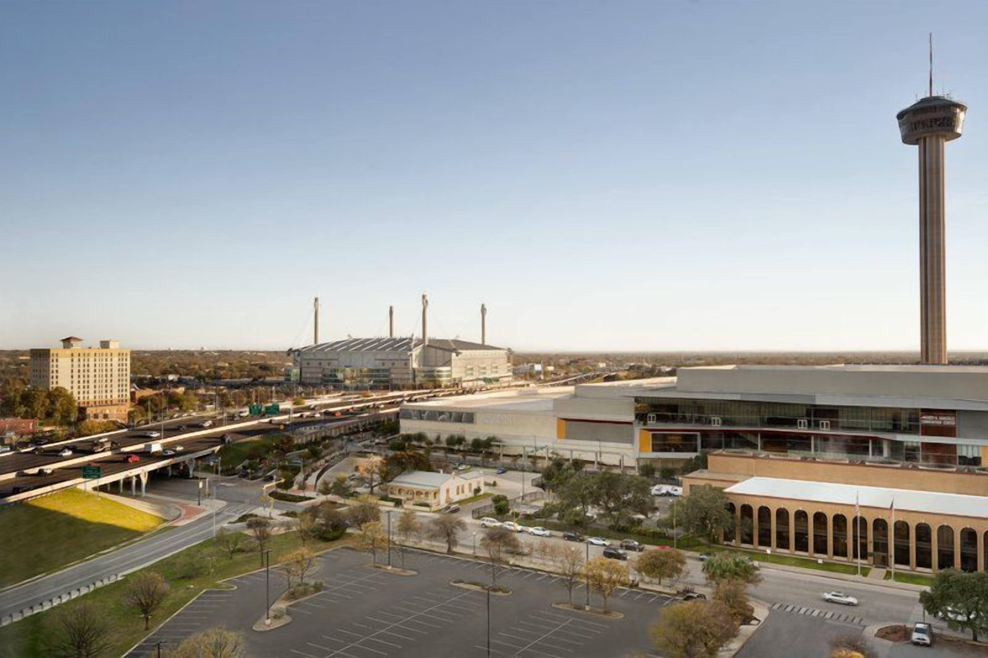 A large building with a tower, parking lots, and a highway.