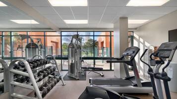 Une salle de sport équipée de tapis de course, d’haltères et d’appareils de musculation.