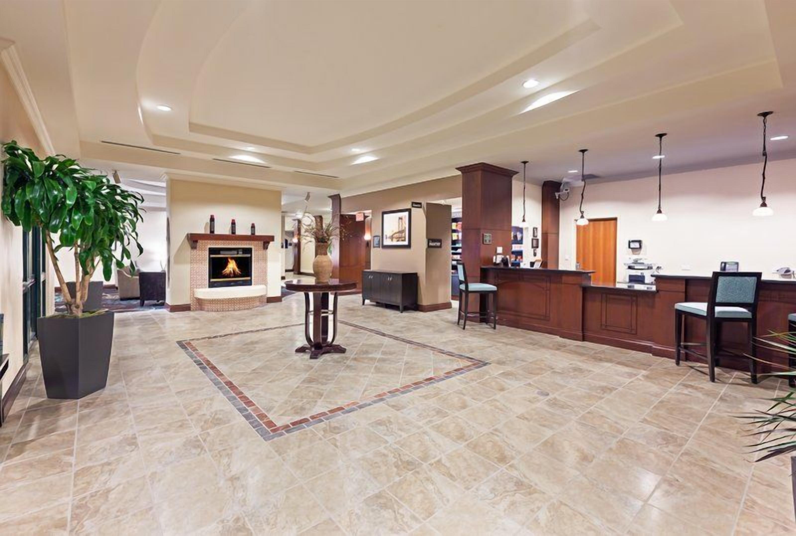 Un hall de hotel con chimenea, mostrador de recepción y zona de estar.