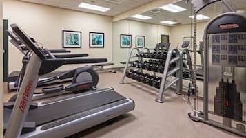 Une salle de sport équipée de machines de cardio, de machines de musculation et d’haltères.