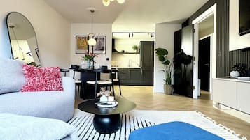 Una sala moderna con un sofá, un reposapiés y un comedor con sillas y una mesa.
