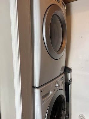 A stacked washer and dryer unit with a control panel and a door. - ENJOY THE COMFORTS OF HOME IN THIS MODERN 6 ROOM CONDO. 1/4 BLOCK TO BEACH! (Seaside Park)