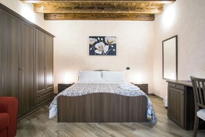 Een slaapkamer met een houten bed, nachtkastjes, een dressoir en een grote spiegel.