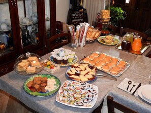 Een buffet met diverse gerechten, waaronder sandwiches, gebak en desserts.